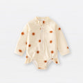Baby girls zip-up swimwear in earthy floral and polka dot patterns with front zipper detail
