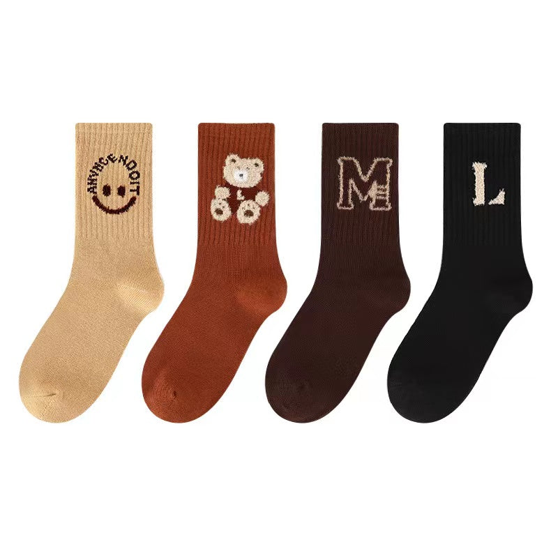 Four pairs of kids soft cotton mid-tube socks in black, apricot, brown, and coffee cartoon patterns