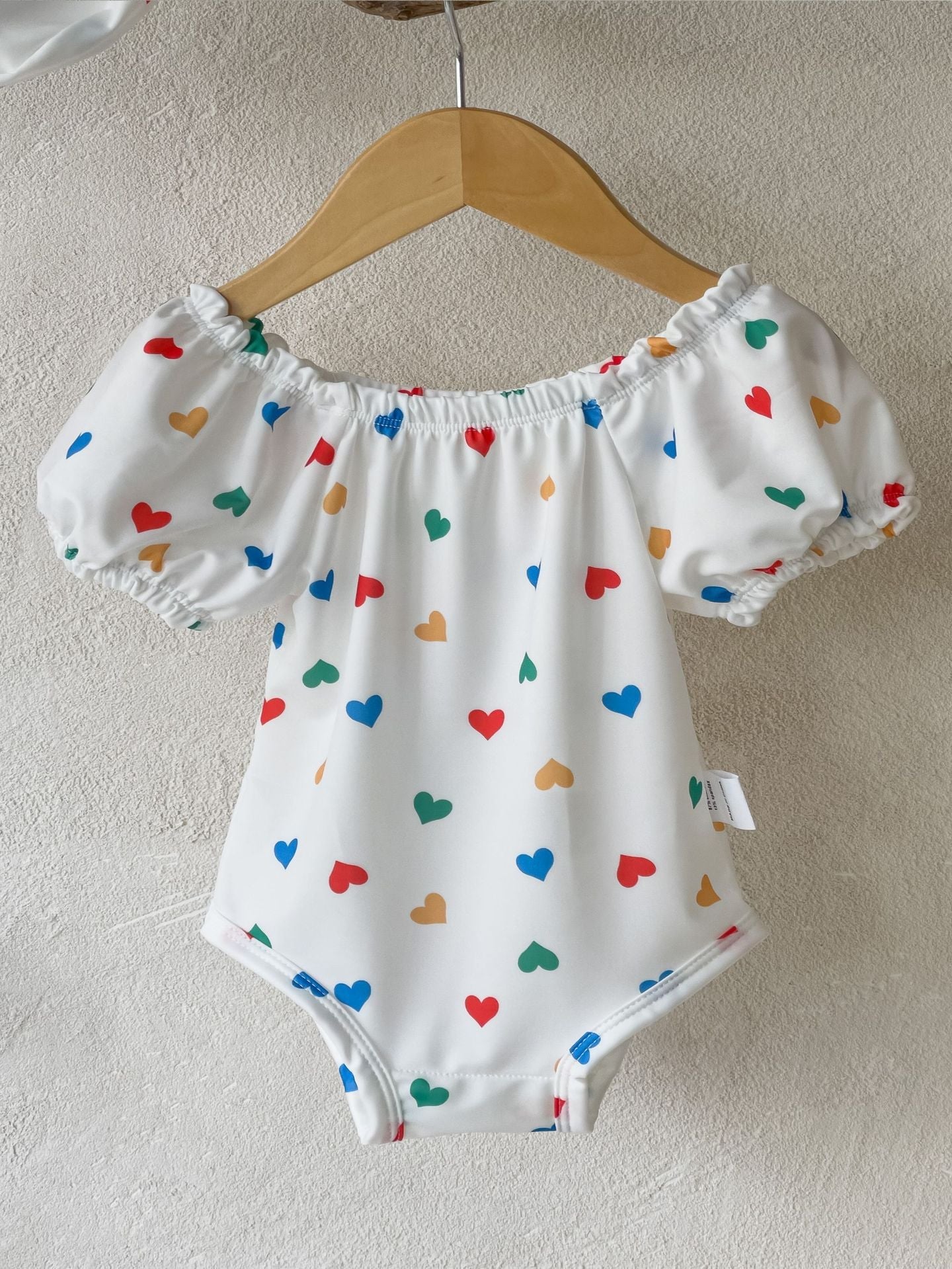 White baby girls one piece swimsuit with red hearts pattern and matching sun protection hat — view 5