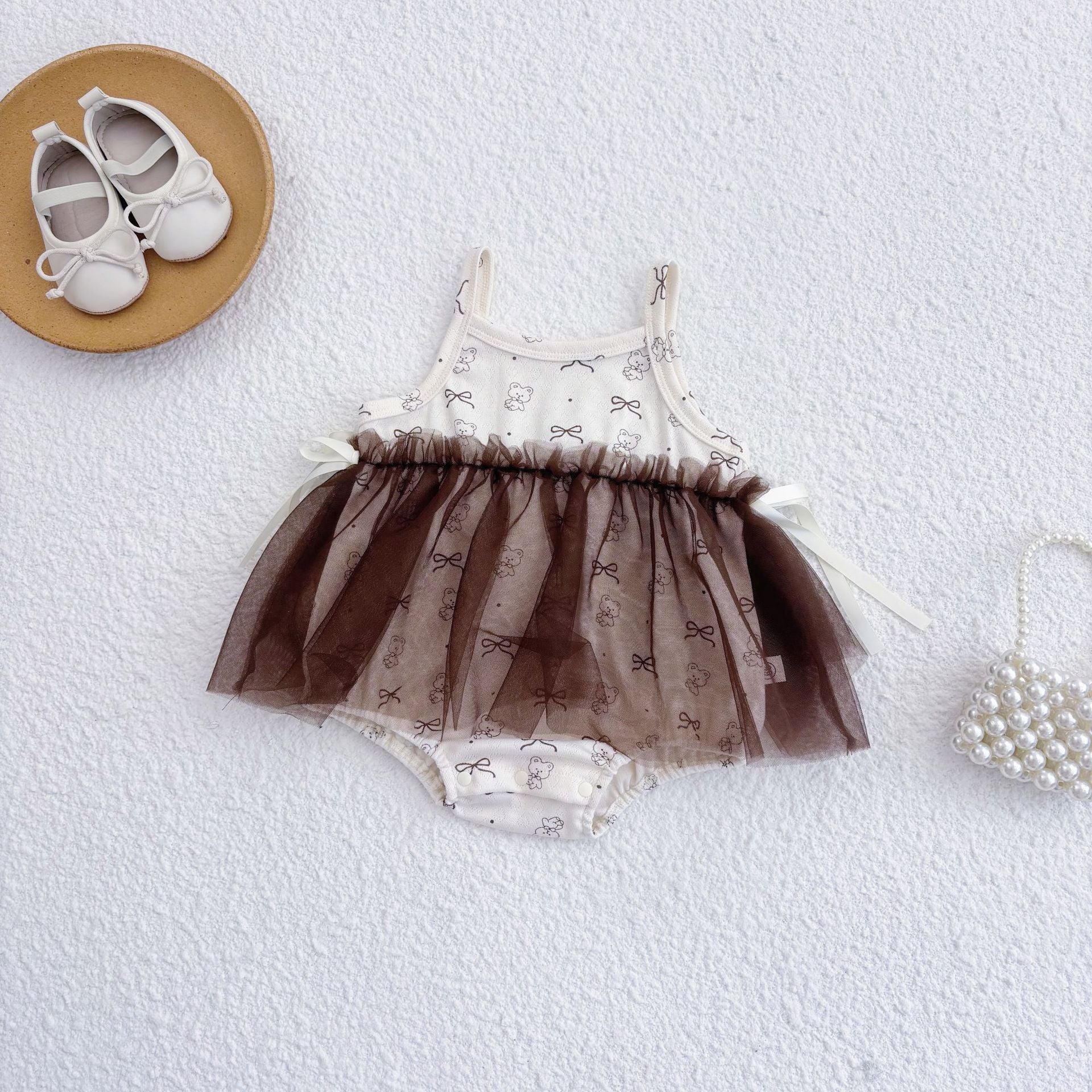 Beige sleeveless baby girl bodysuit featuring a cute teddy bear pattern in soft cotton blend