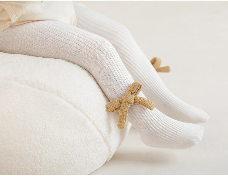 Baby girls knit bow pantyhose in solid color with striped texture and charming side details.