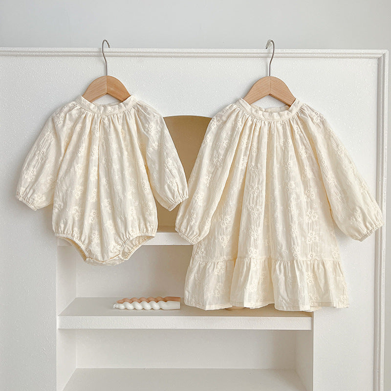 Floral baby girl bodysuit dress in neutral tones with round neckline and snap button bottom closure