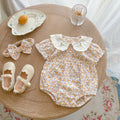 Yellow floral print baby girl bodysuit with an embroidered doll collar made of soft cotton
