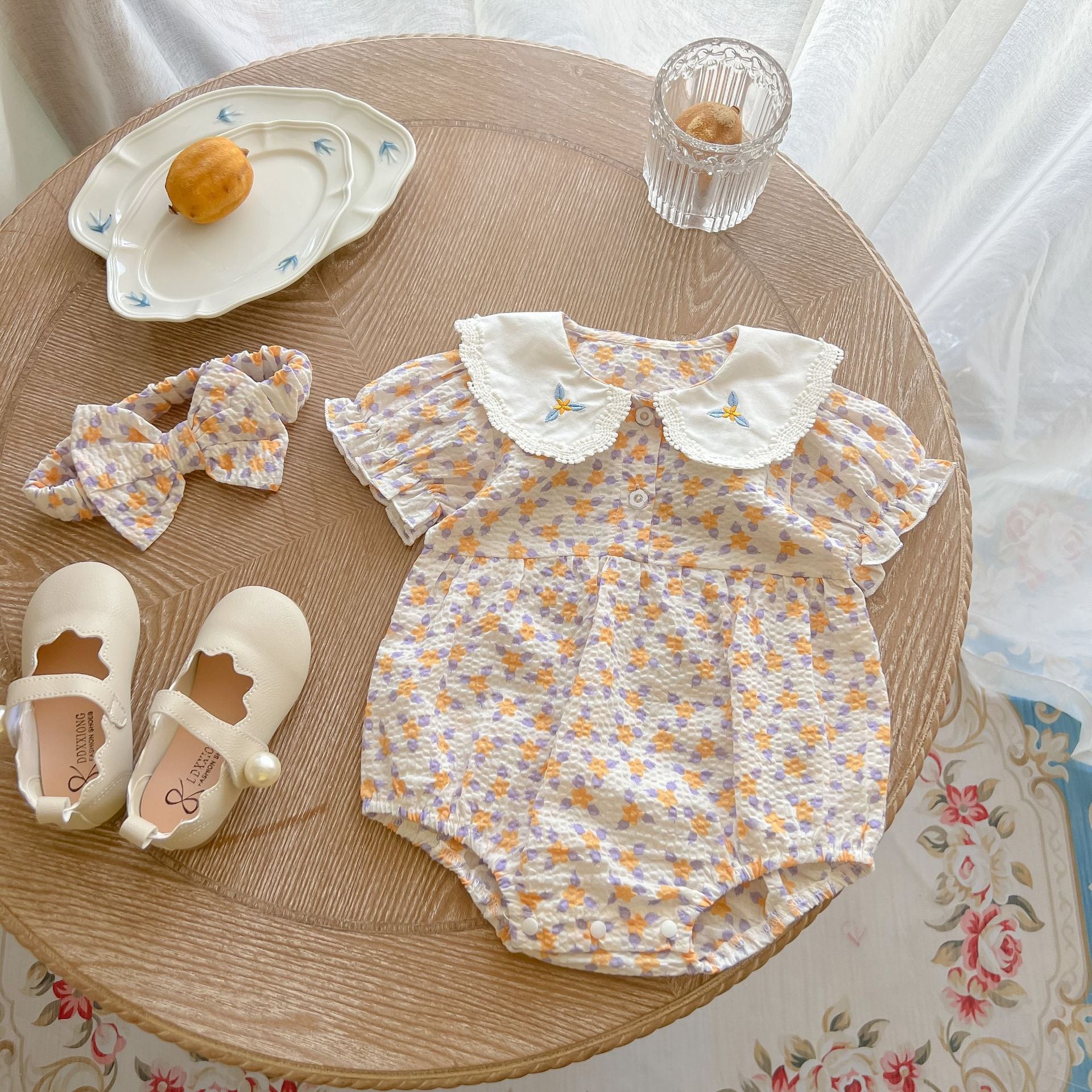 Yellow floral print baby girl bodysuit with an embroidered doll collar made of soft cotton