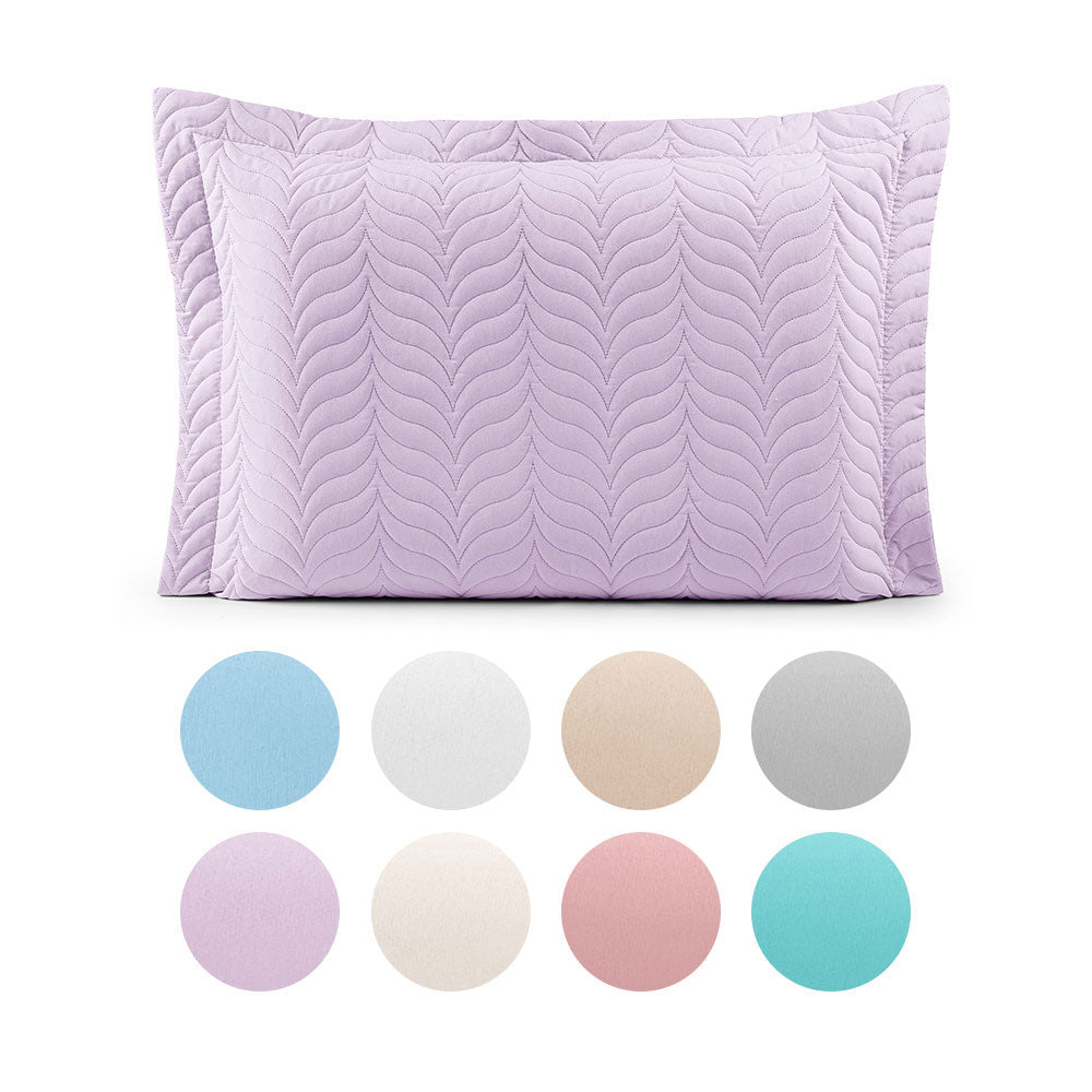 Quilted cotton pillow sham with piped edges and zipper closure for standard bed pillows.