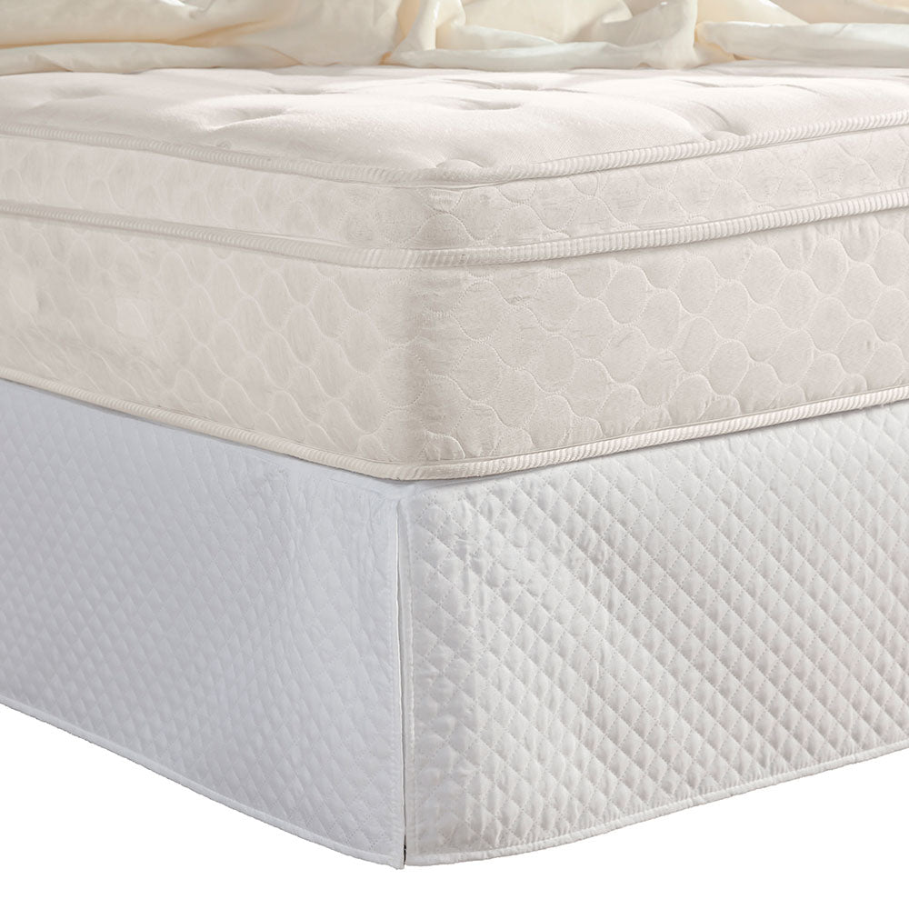 Quilted white full bed skirt with tailored corner pleats covering a standard bedroom box spring — view 2
