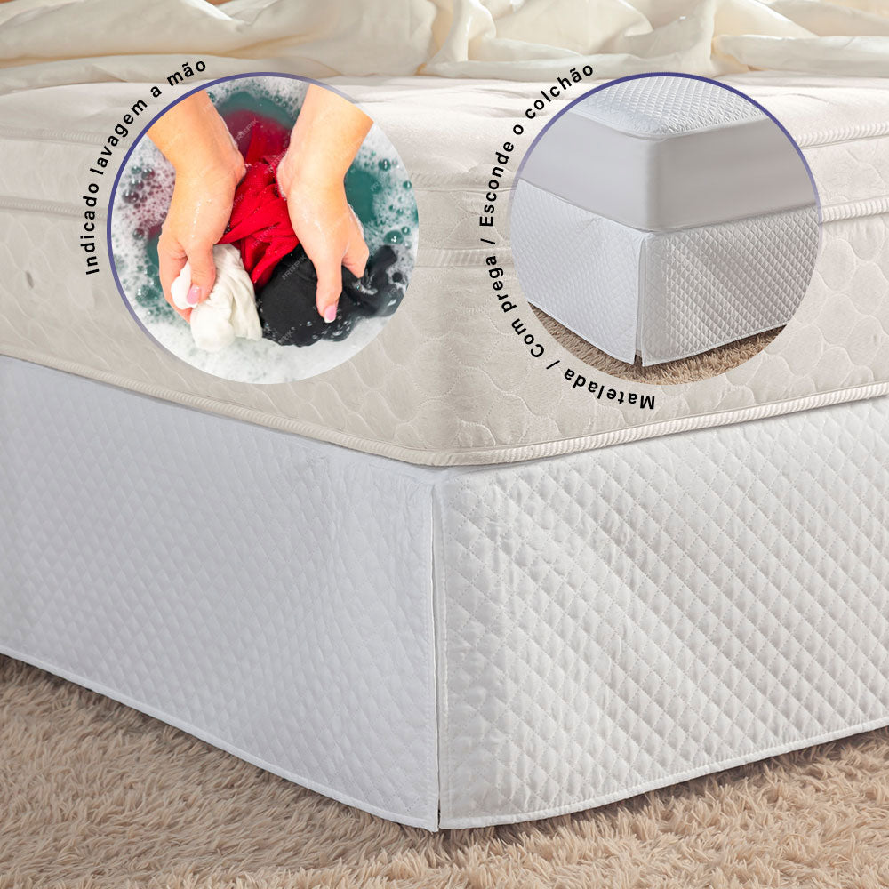 Quilted white full bed skirt with tailored corner pleats covering a standard bedroom box spring