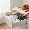 In-drawer knife storage box holding various kitchen knives and cutlery in a modern grey design