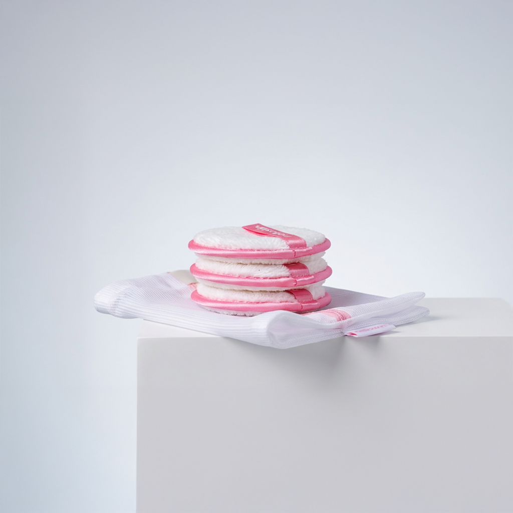 Three reusable microfibre makeup remover puffs with a complimentary mesh laundry wash bag.