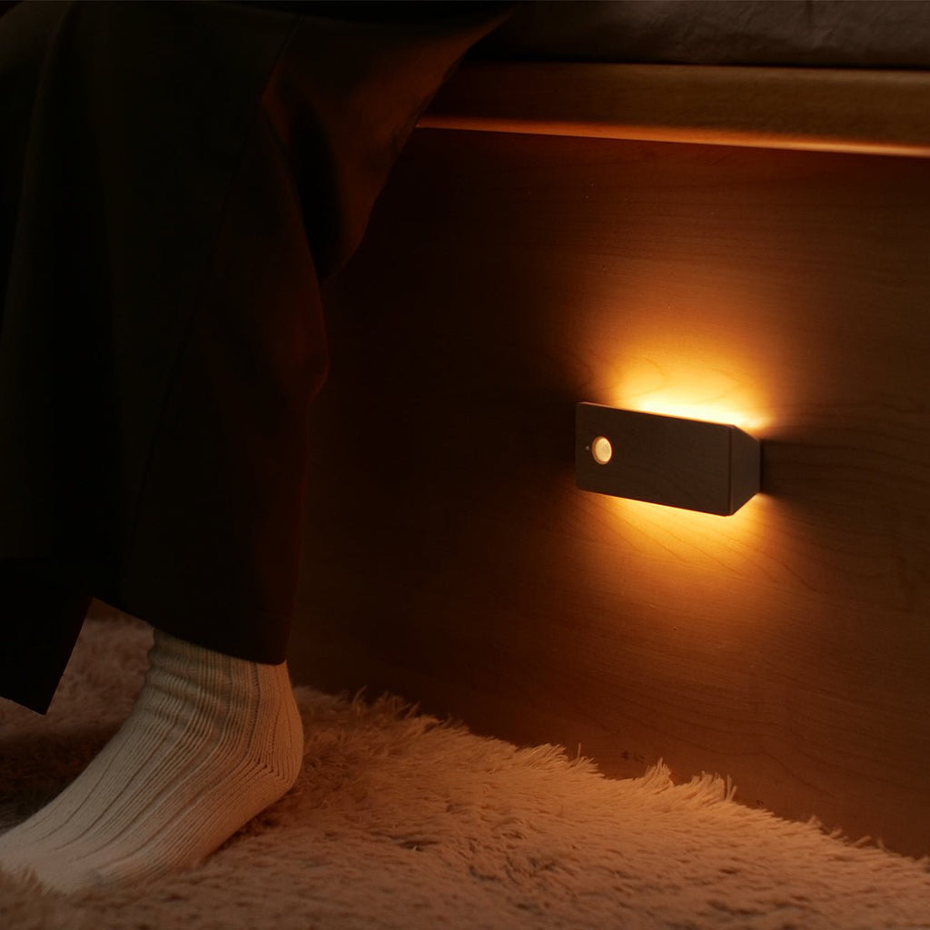 Rechargeable wooden wall night light with magnetic mount emitting a warm LED glow indoors