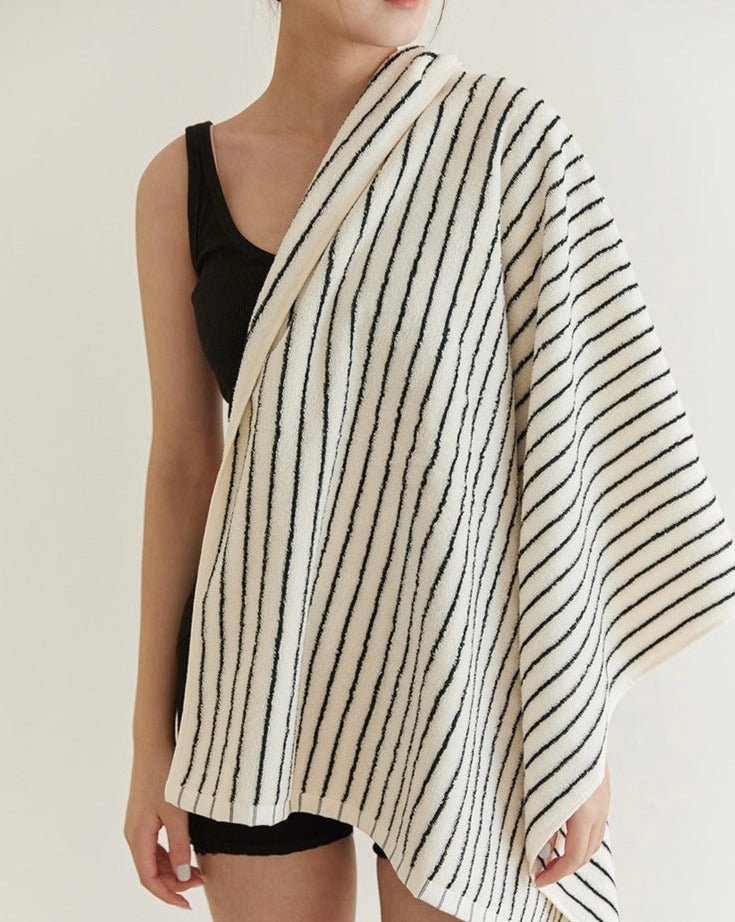 Retro style striped organic combed cotton bath towel folded elegantly in a modern bathroom setting