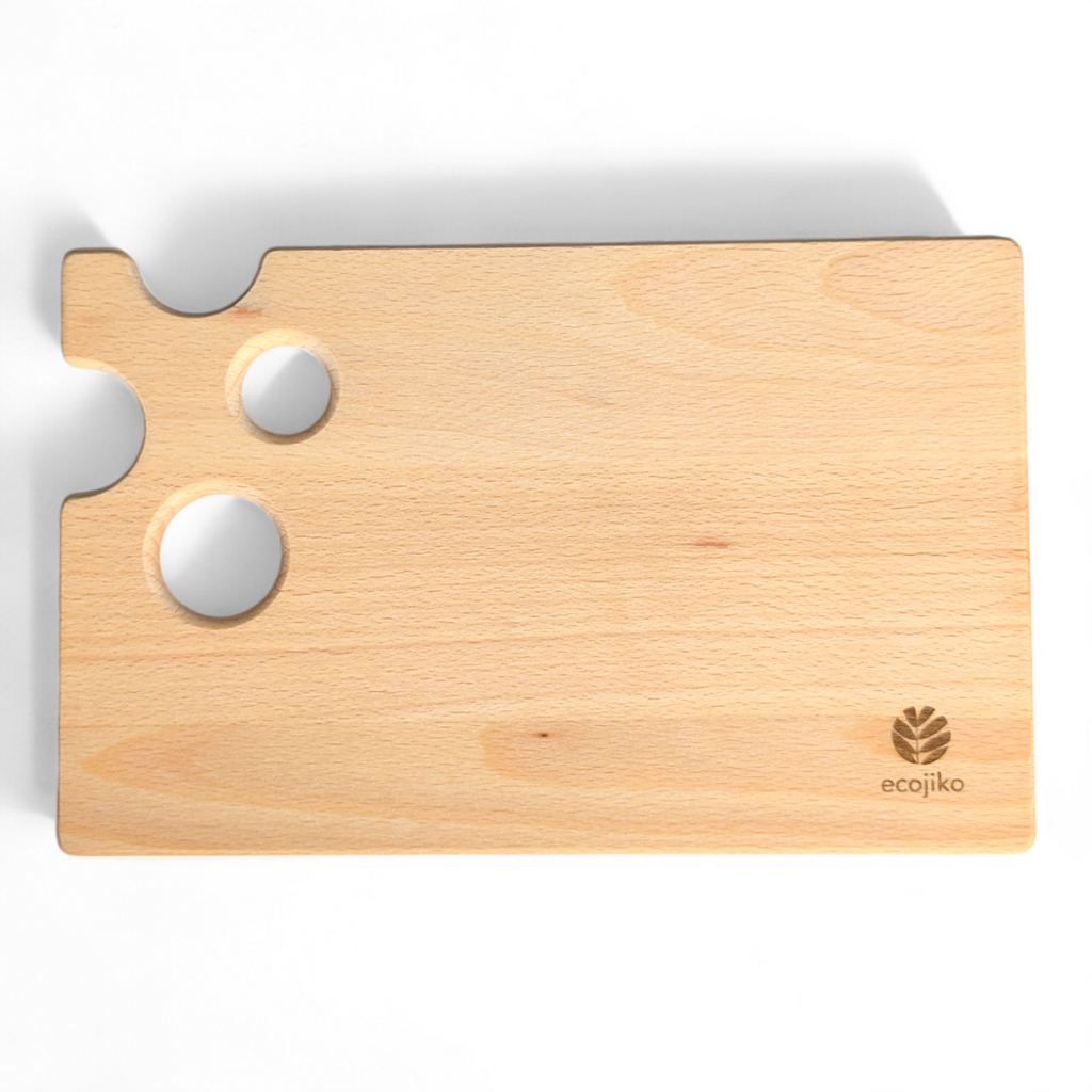 Beech wood cheese board with quirky cutout holes design, resting flat on a table surface — view 2