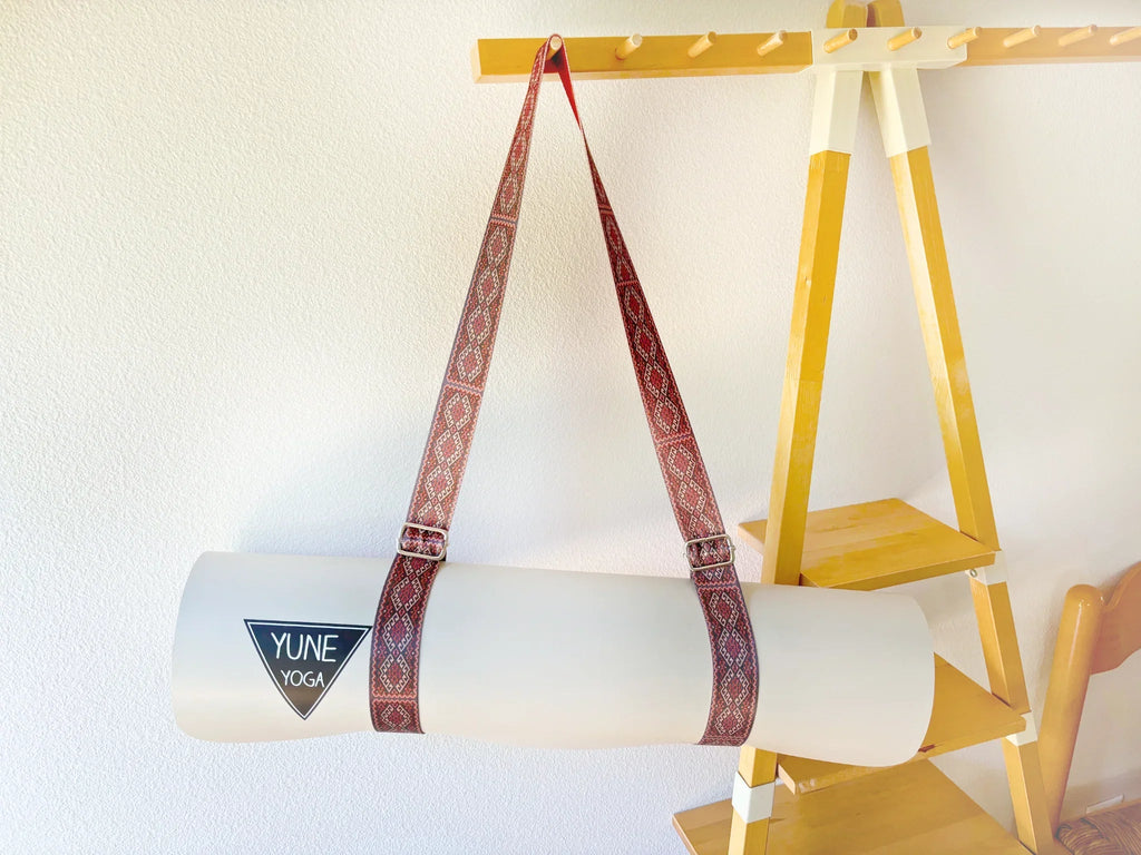 Warm red organic cotton yoga strap with metal D-ring buckles rolled up for studio practice — view 5