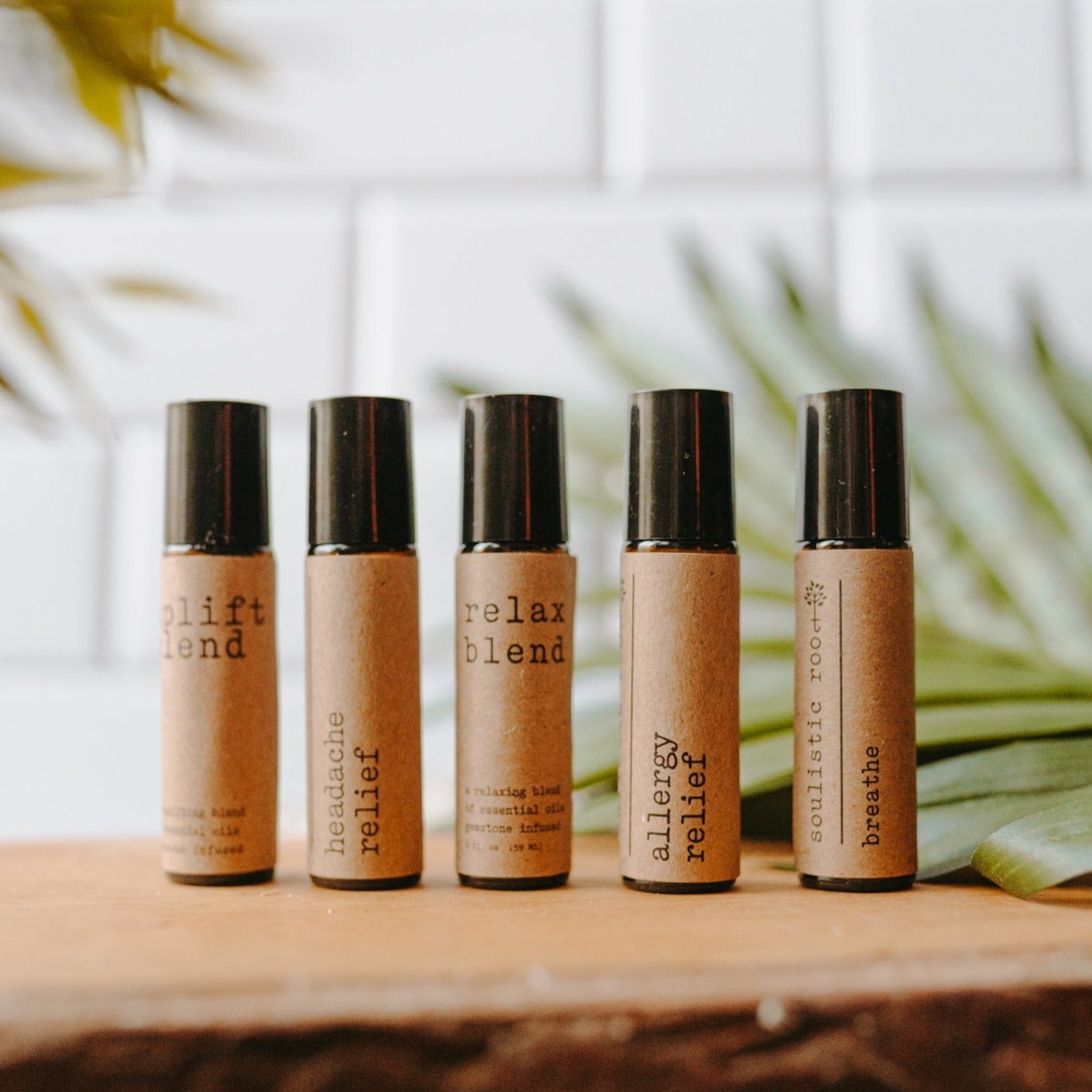 Collection of essential oil rollers with distinct blends infused with crystals in clear glass bottles