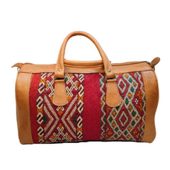Handmade Moroccan leather travel bag with colorful woven carpet patterns, sturdy handles, and adjustable shoulder strap