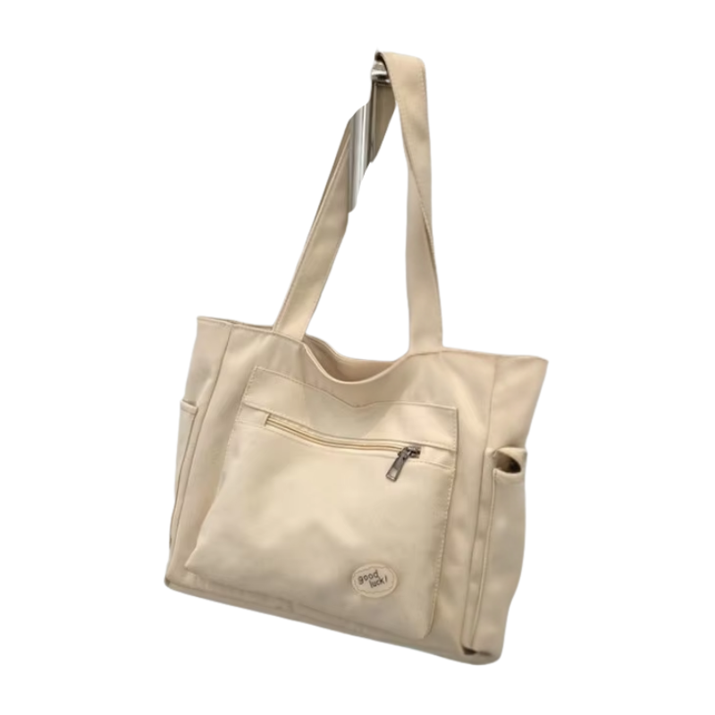 Beige canvas shoulder tote bag for women with embroidery details, rivets, and a secure zipper