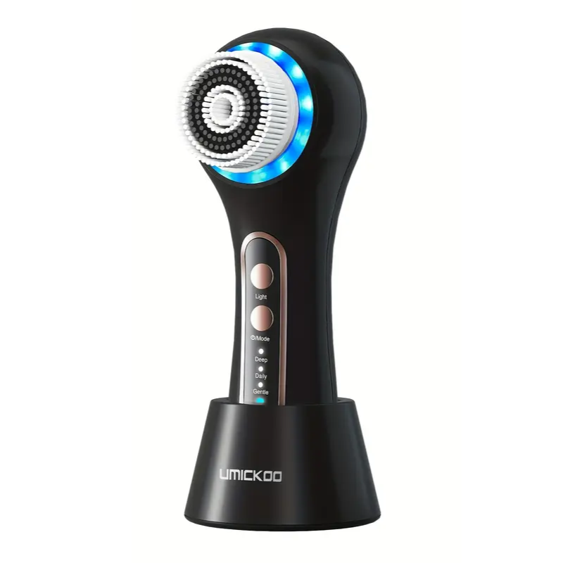 Black rechargeable facial cleansing brush with five interchangeable heads and stand on a clear background