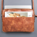 Genuine leather laptop bag with shoulder strap, soft suede interior, and front pocket for professional use.