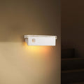 Smart motion magnetic wall light emitting a warm white glow mounted on a modern wall