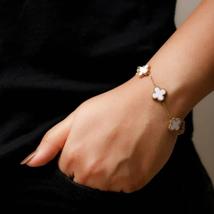 White four-leaf clover lucky charm bracelet on a minimalist adjustable gold-tone chain — view 2