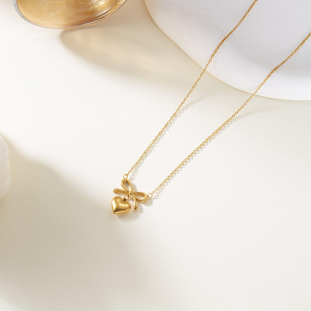 Dainty 18k gold plated bow heart pendant necklace with an adjustable chain on clean background — view 3