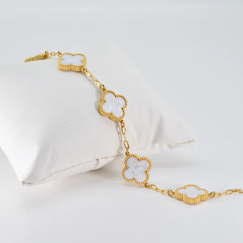 White four-leaf clover lucky charm bracelet on a minimalist adjustable gold-tone chain — view 4