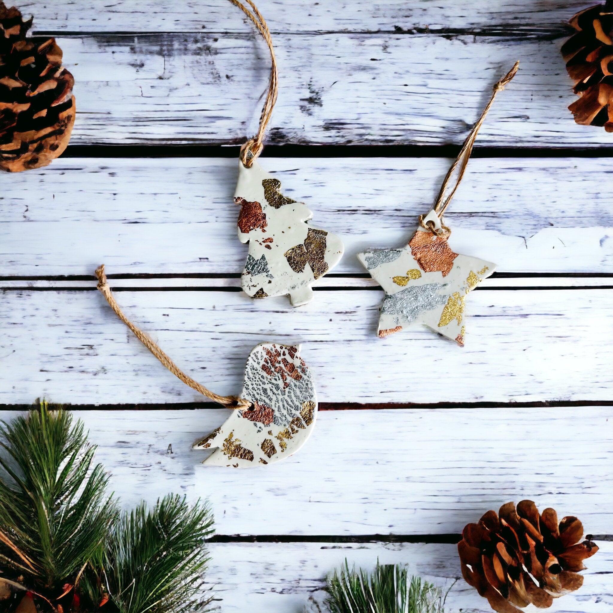 Set of three white polymer clay Christmas ornaments with gold silver and copper foil flakes.