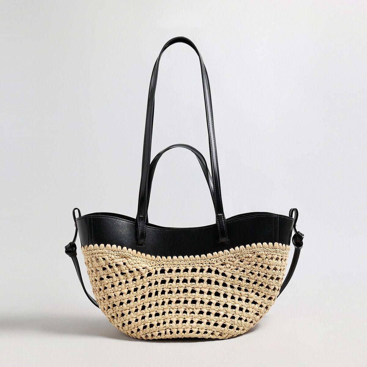 Handwoven natural straw and leather tote bag with multi-pocket interior and dual shoulder handles
