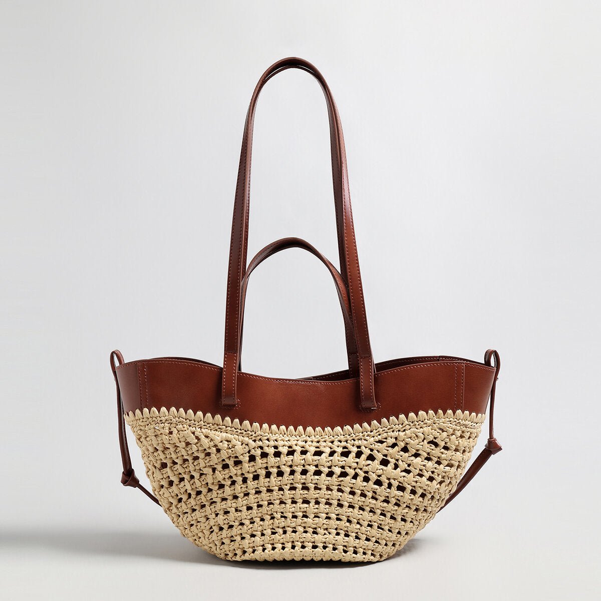 Handwoven natural straw and leather tote bag with multi-pocket interior and dual shoulder handles — view 2