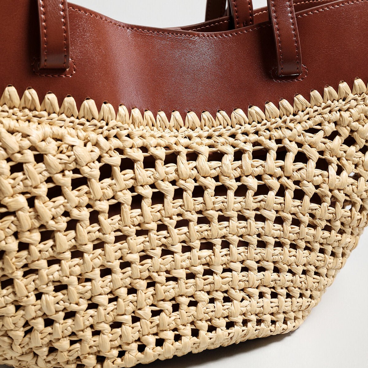Handwoven natural straw and leather tote bag with multi-pocket interior and dual shoulder handles — view 4