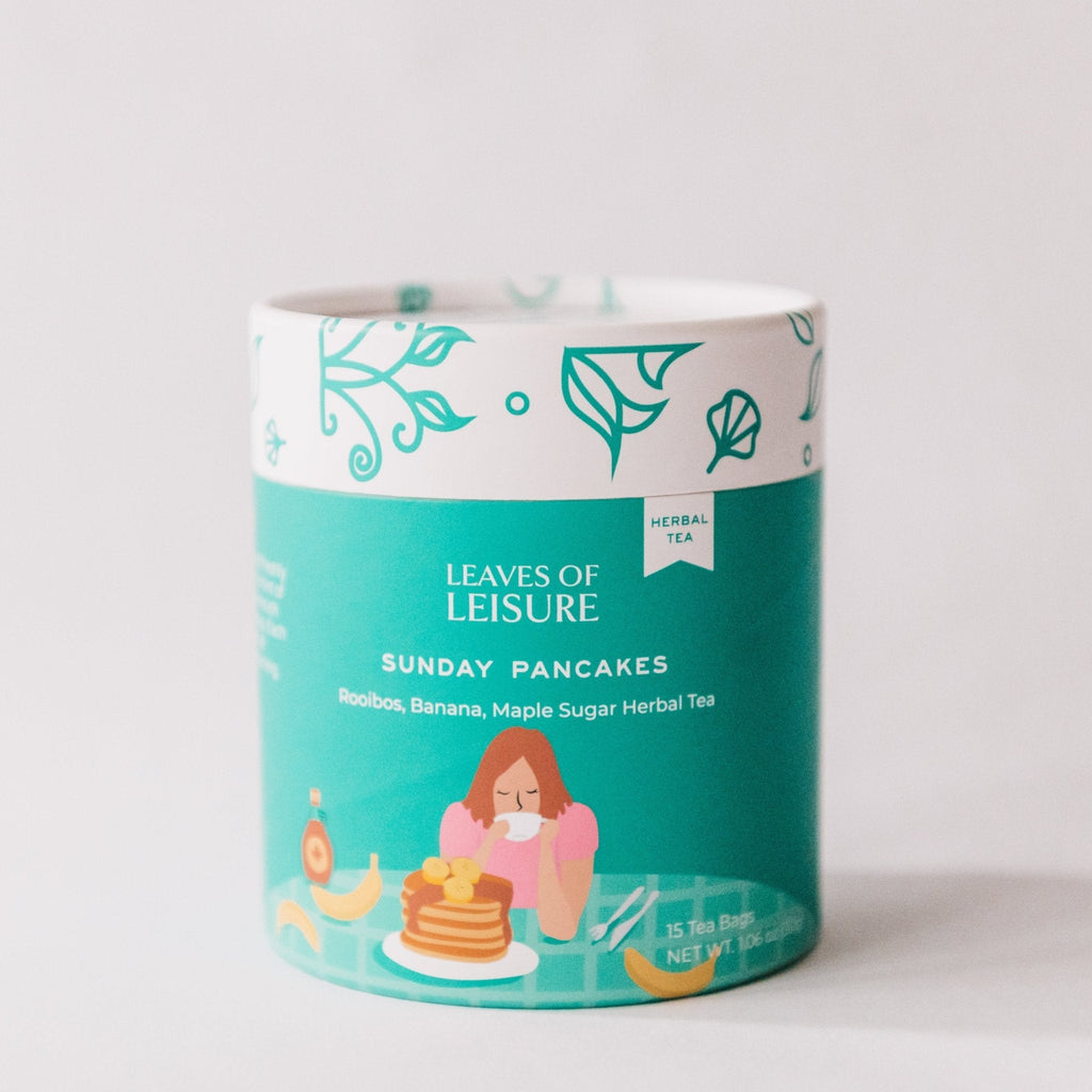 Sunday Pancakes herbal tea in a reusable paper canister alongside compostable corn mesh tea bags