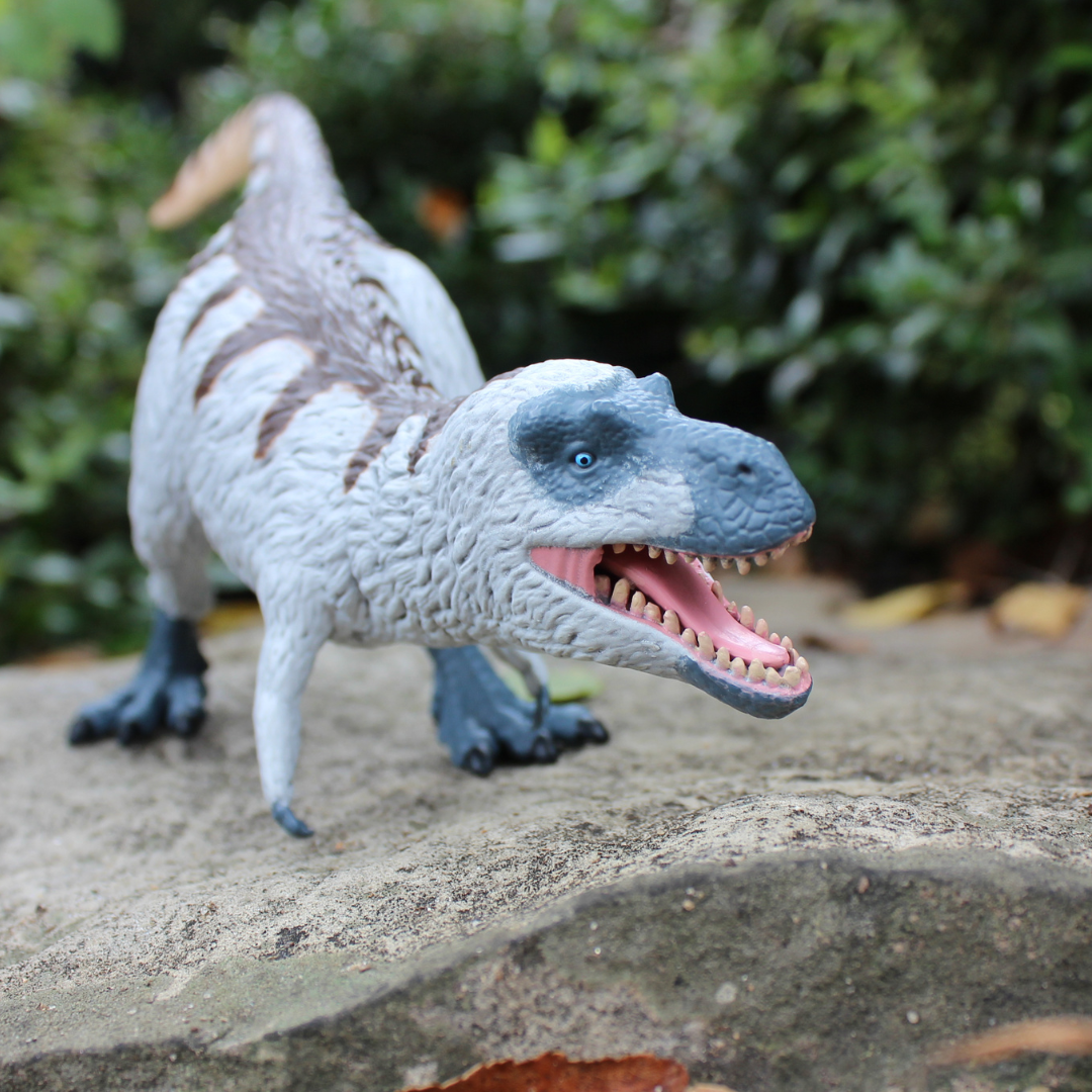Nanuqsaurus toy dinosaur figure with white feathers and blue-gray skin in a dynamic standing pose — view 3