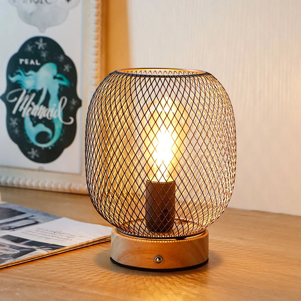 Bronze cage lantern style touch table lamp with wooden base and glowing golden LED bulb