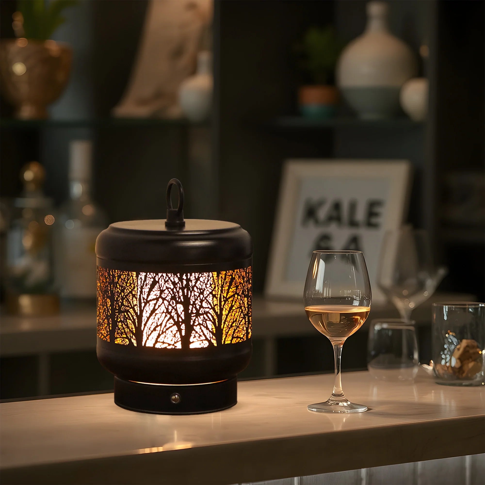 Rechargeable metal desk lamp with tree silhouette cutouts glowing in warm light on a table — view 5