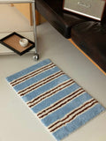 Retro blue stripe bath rug on floor, ultra soft and highly absorbent fluffy bathroom mat
