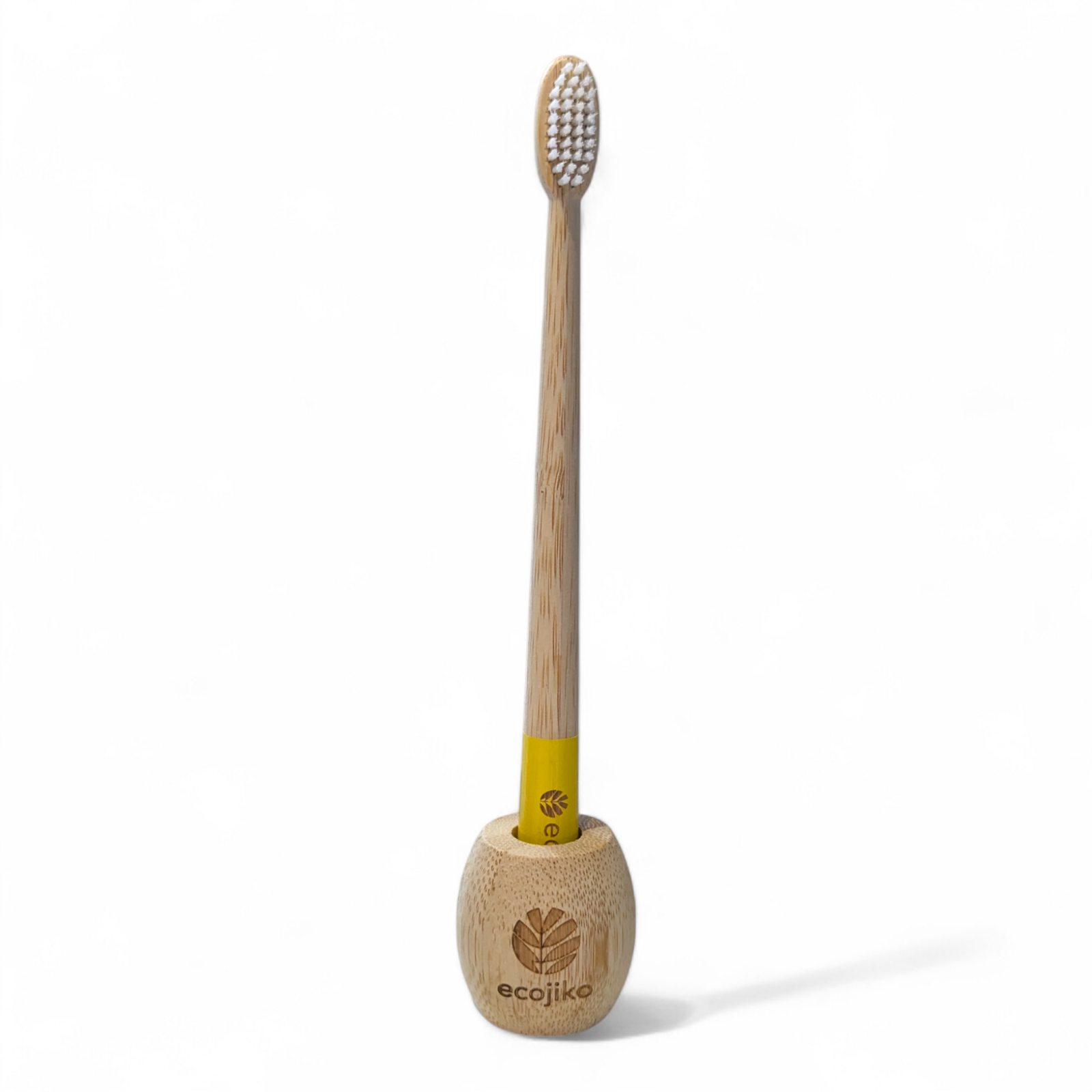 Unwaxed bamboo toothbrush stand on a bathroom counter holding a wooden adult toothbrush — view 4