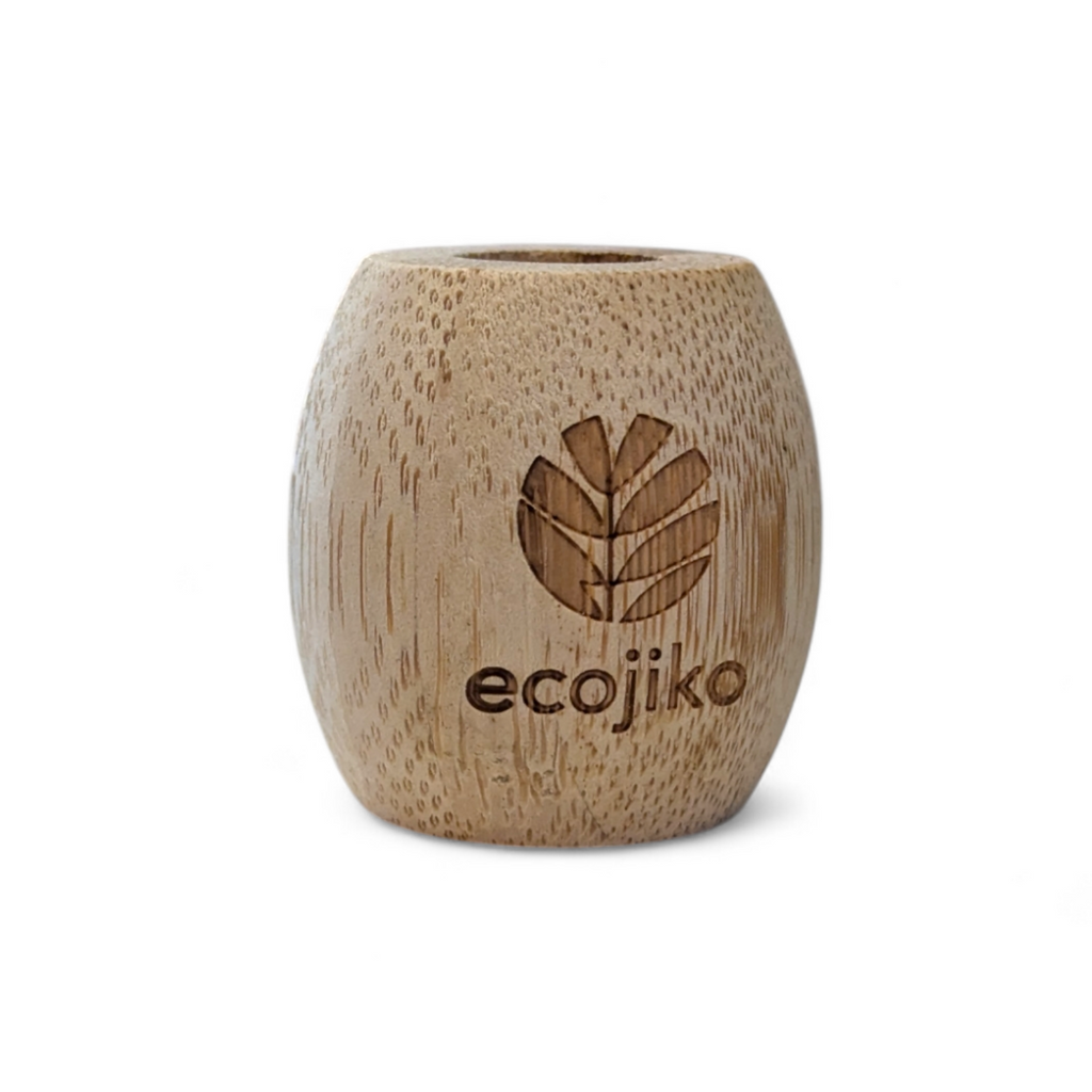 Unwaxed bamboo toothbrush stand on a bathroom counter holding a wooden adult toothbrush