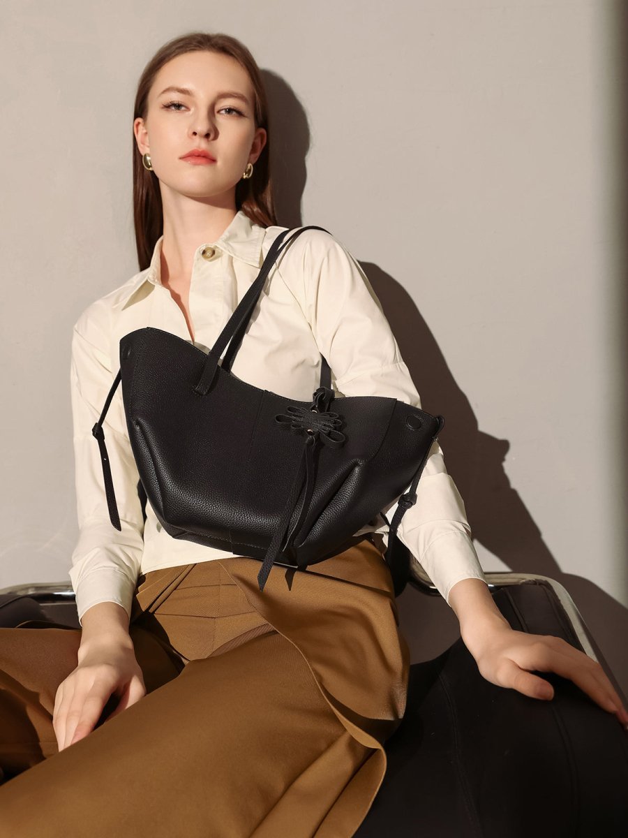 Pebbled leather trapezoid tote bag featuring a sculptural front knot detail and long shoulder straps — view 2