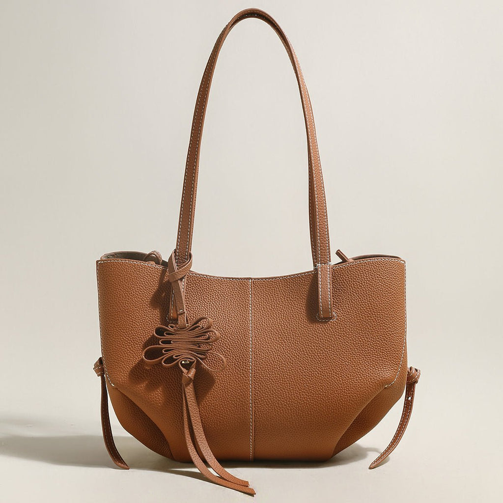Pebbled leather trapezoid tote bag featuring a sculptural front knot detail and long shoulder straps — view 3
