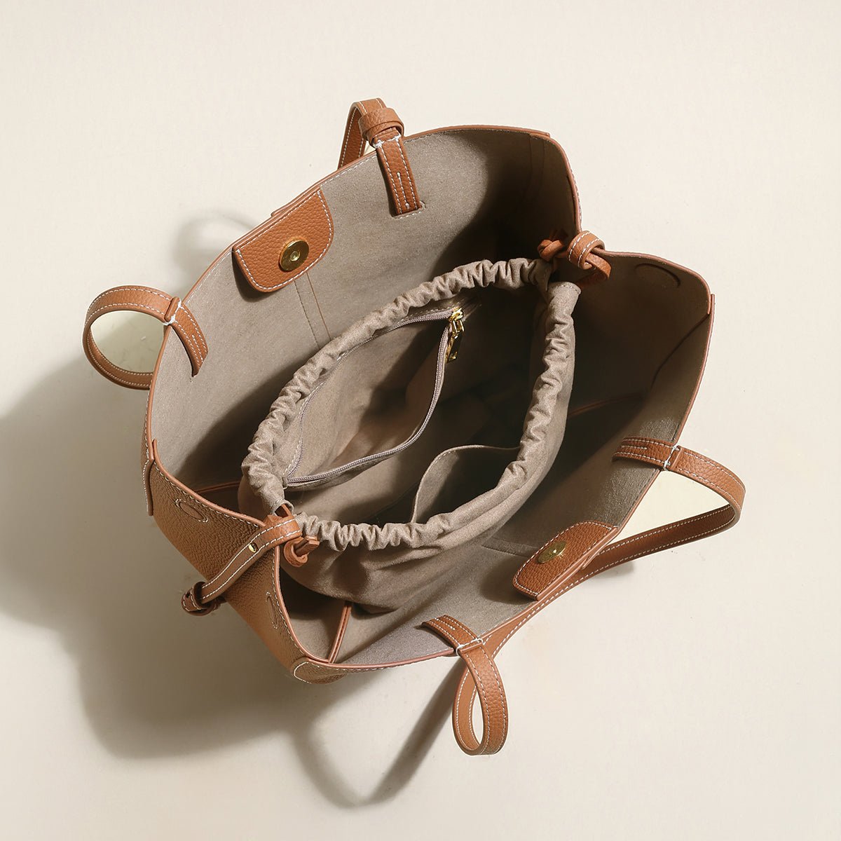 Pebbled leather trapezoid tote bag featuring a sculptural front knot detail and long shoulder straps — view 5