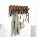 Solid walnut wood wall-mounted coat rack featuring eight retractable hooks in a modern piano key design
