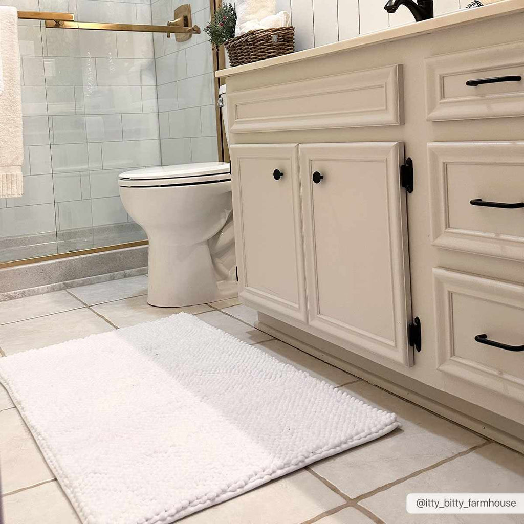 Plush solid white washable bath mat made of thick absorbent polyester for bathroom floors